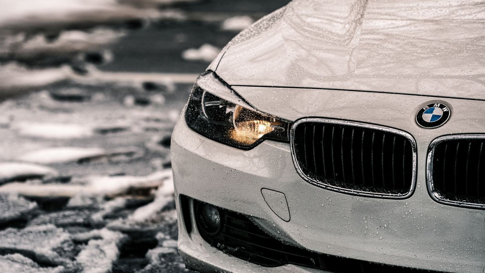 Frost-covered car with headlights on during a freezing morning — cold weather exposes weak car batteries